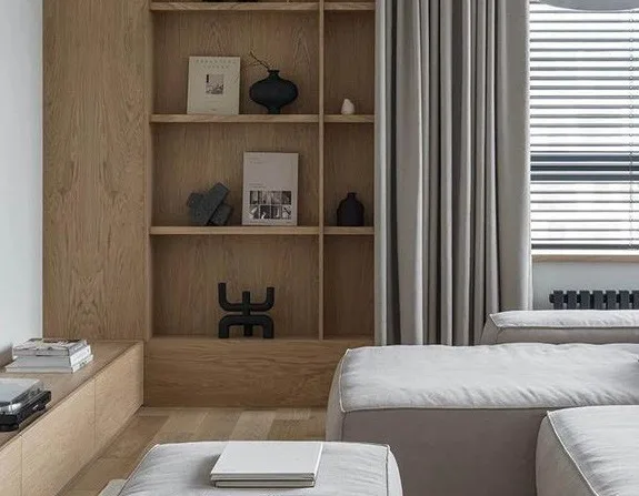 Timber shelving with ceramic objects beside linen curtains